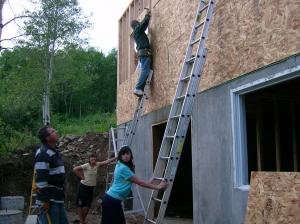 Putting up the wall sheathing on ladders